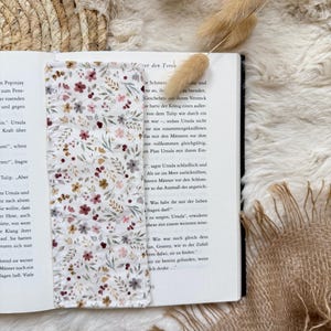 Handgefertigte Buchhülle aus grauem Cord mit romantischem Blumenmuster und Druckknopfverschluss zum Schutz von Taschenbüchern und Hardcovern.