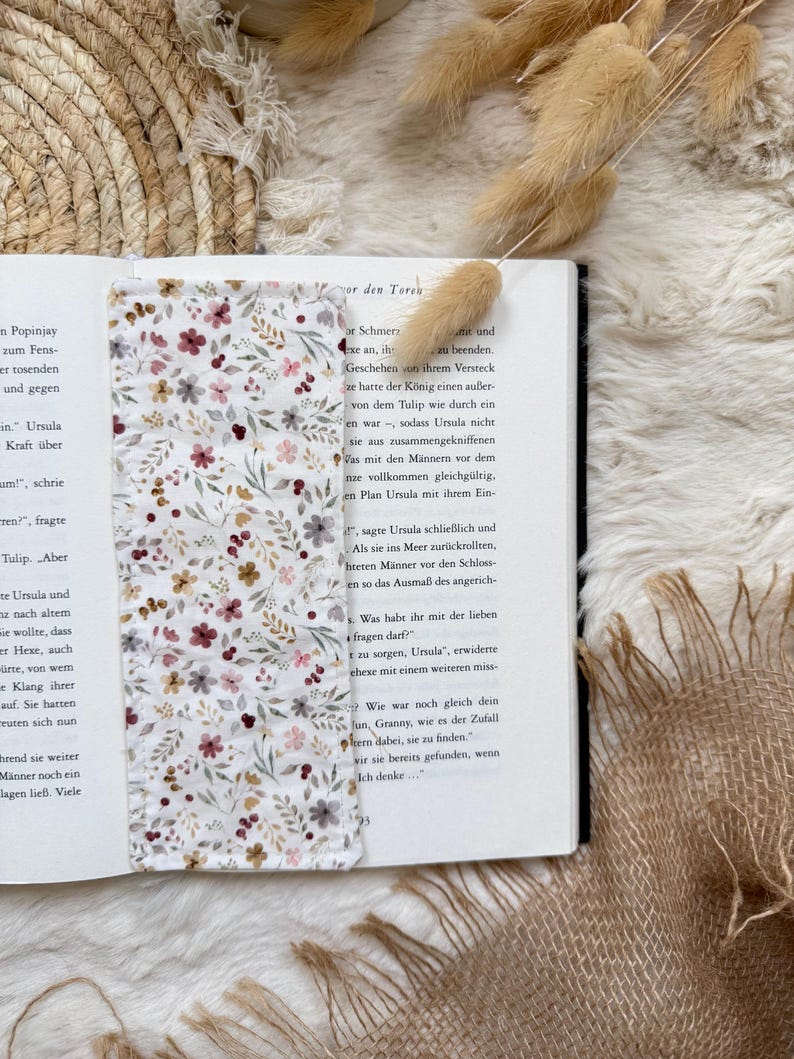 Handgefertigte Buchhülle aus grauem Cord mit romantischem Blumenmuster und Druckknopfverschluss zum Schutz von Taschenbüchern und Hardcovern.