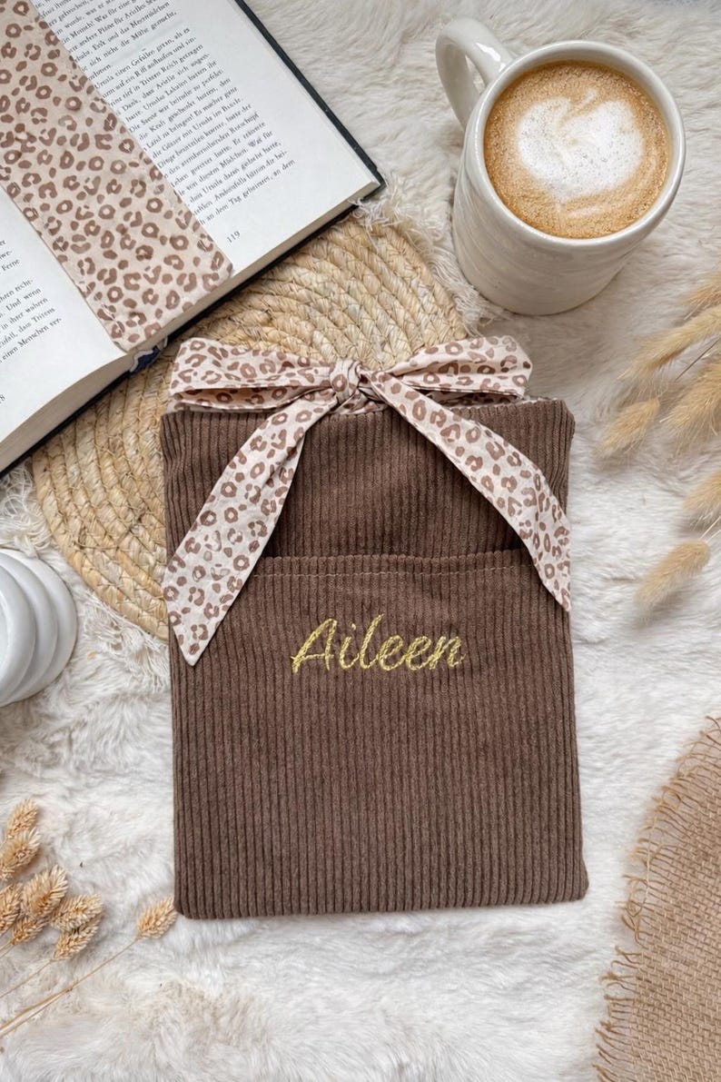bestickte Buchhülle mit goldenen Garn. Namen bestickt mit Strickmaschine langliebig
