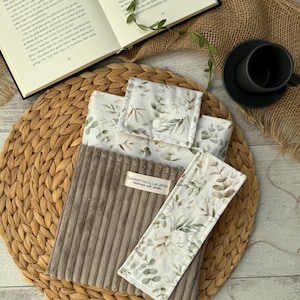 Stoff-Buchhülle mit Blättermuster in Naturtönen, handgenäht von SweetWoollyLand – perfekte Geschenkidee für Leseratten.