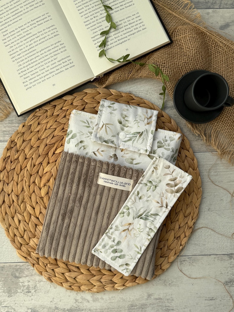 Stoff-Buchhülle mit Blättermuster in Naturtönen, handgenäht von SweetWoollyLand – perfekte Geschenkidee für Leseratten.