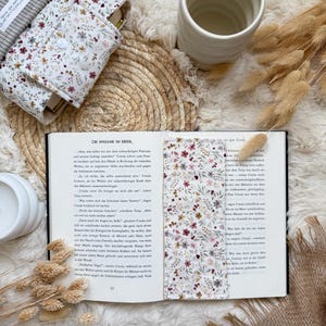 Detailaufnahme der Cord Buchhülle mit Blumenmuster, Druckknopf und hochwertiger Handarbeit.