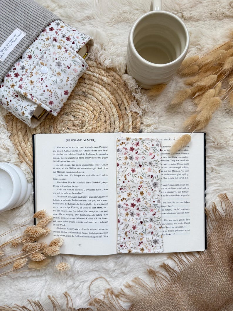 Detailaufnahme der Cord Buchhülle mit Blumenmuster, Druckknopf und hochwertiger Handarbeit.