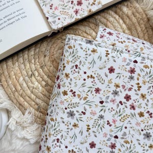 Handgefertigte Buchtasche aus grauem Cord mit romantischem Blumenmuster und Druckknopfverschluss zum Schutz von Taschenbüchern und Hardcovern.