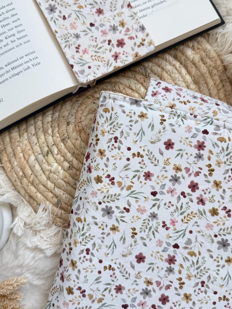 Handgefertigte Buchtasche aus grauem Cord mit romantischem Blumenmuster und Druckknopfverschluss zum Schutz von Taschenbüchern und Hardcovern.
