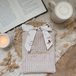 Personalisierte handgemachte Buchhülle aus hochwertigem beigem Breitcord mit eleganter goldener Namensstickerei und romantischem Kirschblüten Innenstoff, weich gefüttert zum Schutz von Taschenbüchern, Hardcovern und Kindle – cozy Book Sleeve im Cottagecore Stil für Booklover, Leseratten und Booktok Fans, perfekt als besonderes Geschenk für gemütliche Lesestunden zuhause oder unterwegs