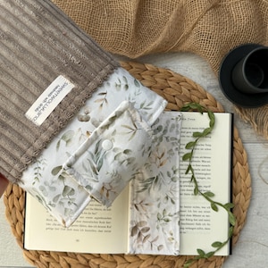 Umweltfreundliche Stoffhülle für Bücher im botanischen Stil, in Beige und Grün, mit Druckknopfverschluss.