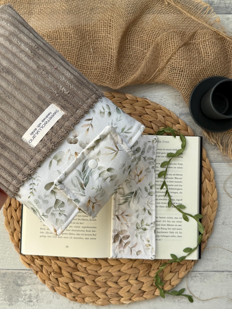 Umweltfreundliche Stoffhülle für Bücher im botanischen Stil, in Beige und Grün, mit Druckknopfverschluss.