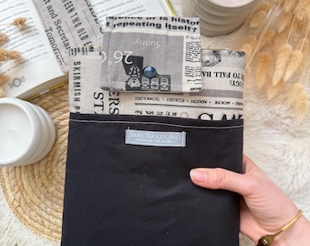 Peut inclure: Une pochette en tissu rectangulaire avec un motif d'imprimé journal sur la partie supérieure et une section inférieure noire unie. La pochette possède un rabat avec un bouton foncé et une petite étiquette rectangulaire SWEETJOLLYLAND.