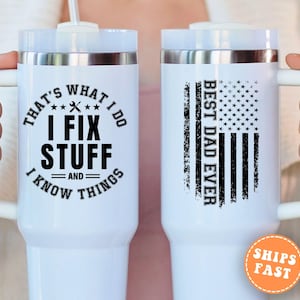 May include: White insulated tumbler with a handle. One side reads "THAT'S WHAT I DO, I FIX STUFF, AND I KNOW THINGS" in black. The other side features an American flag design and the text "BEST DAD EVER".