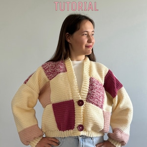 Può includere: Un cardigan all'uncinetto con un design a patchwork in crema, rosa e bordeaux. Il cardigan ha una chiusura con bottoni e maniche lunghe.