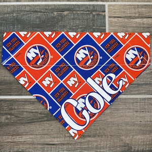 May include: A blue and orange dog bandana with the New York Islanders logo and the name "Cole" printed in white.