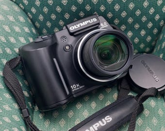 Olympus SP-500UZ: Câmera digital bridge com sensor CCD de 6,0 megapixels e zoom grande angular de 10x.