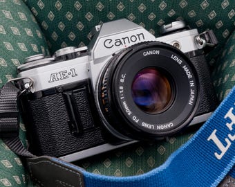 Câmera Canon AE-1 SLR de 35 mm com lente fixa de 50 mm f/1.8, testada com filme.