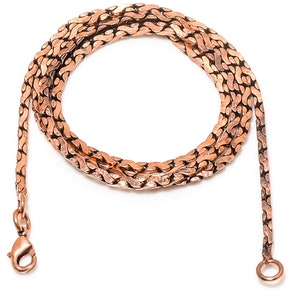 May include: A copper chain necklace with a lobster clasp and a round ring clasp. The chain is a box chain style.