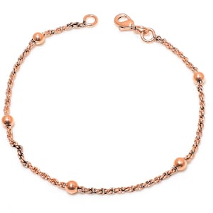 May include: A rose gold bracelet featuring a delicate rope chain design. The bracelet is adorned with five small, round beads evenly spaced along the chain. It has a lobster clasp closure for secure wear.