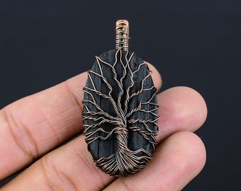 Könnte beinhalten: Ein Anhänger aus schwarzem Obsidian mit einem Baum des Lebens aus Kupferdraht.