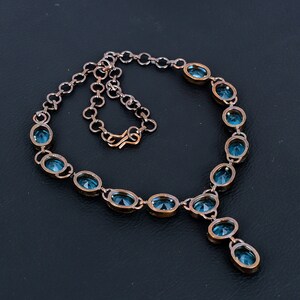 May include: A copper necklace with a pendant and oval-shaped blue gemstones.