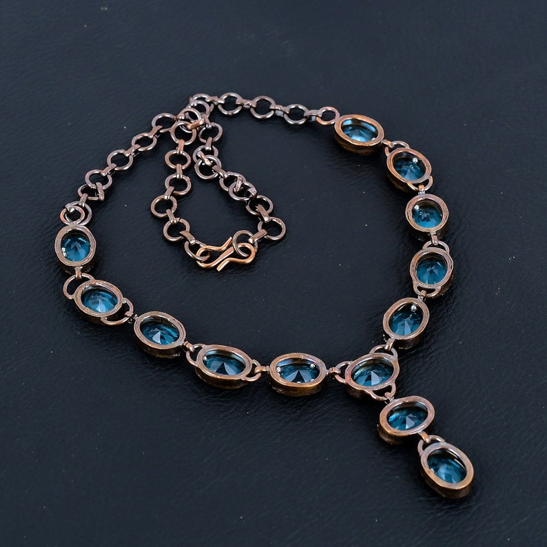May include: A copper necklace with a pendant and oval-shaped blue gemstones.