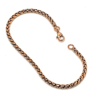 May include: A gold-toned copper bracelet with a braided chain design and a lobster claw clasp.
