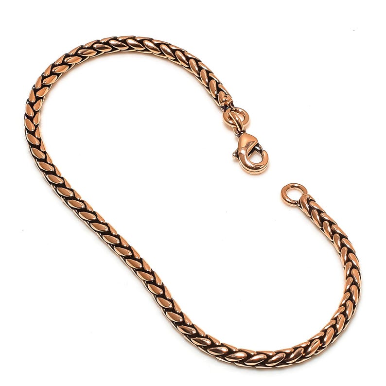 May include: A gold-toned copper bracelet with a braided chain design and a lobster claw clasp.