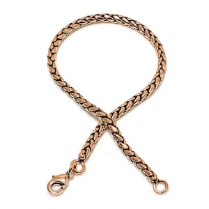 May include: A gold-toned chain bracelet with a lobster clasp closure. The chain is made of a braided design.