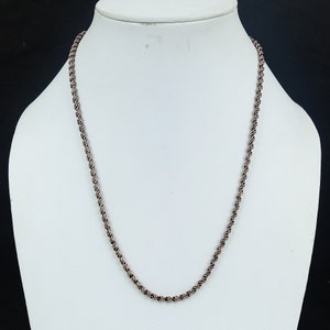 May include: A silver-toned rope chain necklace on a white mannequin.