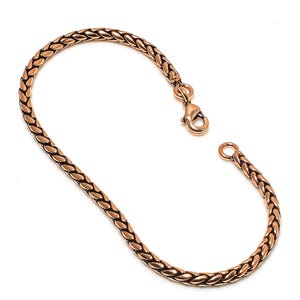 May include: A gold-toned copper bracelet with a braided chain design and a lobster clasp closure.