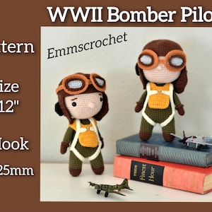 May include: Two crocheted WWII Bomber Pilot dolls, approximately 30 cm tall, with brown hair, goggles, and flight suits. The dolls are standing on books with miniature airplanes. The text "WWII Bomber Pilot" and "Emmscrochet" are visible.