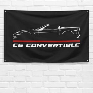 May include: Black flag featuring a white silhouette of a C6 Corvette convertible and the text "C6 CONVERTIBLE" in white with a red stripe above the text.