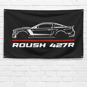 Puede incluir: Ilustración en blanco y negro de un Roush 427R Mustang en una bandera negra con texto rojo y blanco.