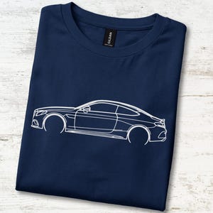 Può includere: Una t-shirt blu navy con una grafica a linee bianche di un'auto coupé a due porte sul davanti. La maglietta presenta un girocollo e un'etichetta nera del marchio Gildan visibile all'interno del colletto, mostrando un design pulito.
