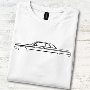 May include: A white short-sleeve t-shirt featuring a black line art illustration of a classic two-door coupe car in profile. The shirt has a crew neckline and a black Gildan brand label visible at the inner collar area of the garment.