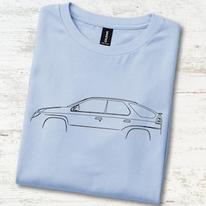 May include: A light blue t-shirt featuring a black line art illustration of a car profile on the front. The shirt has a crew neckline and a black Gildan brand label visible at the inside of the collar. The design depicts the side view of a vehicle.