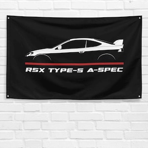 Peut inclure: Drapeau noir avec une illustration de voiture blanche et noire et une bande rouge. Le texte "RSX TYPE-S A-SPEC" est imprimé en blanc sous la bande rouge. Le drapeau est accroché à un mur de briques blanches.