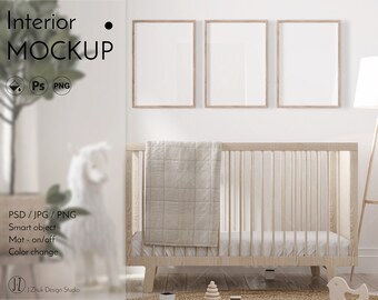 May include: A white crib with a white blanket and three framed pictures on the wall behind it. The crib is in a room with a wooden floor and a white lamp.