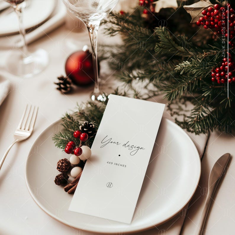 May include: A white card with the text "Your design 4x9 inches" on a white plate with a sprig of greenery and red berries. The plate is set on a table with a white tablecloth and a glass of water.