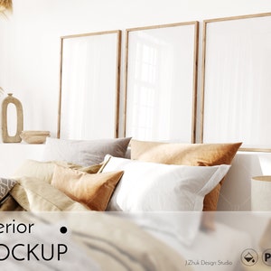 Puede incluir: Una maqueta de interior de dormitorio con tres marcos vacíos colgados en la pared sobre una cama con almohadas blancas, beige y marrones. La cama está hecha con un edredón beige y una manta de tiro estampada. Hay una pequeña lámpara de mesa en la mesita de noche.
