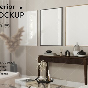 May include: A mockup of a living room interior with three empty picture frames, a wooden console table with two drawers, and a glass coffee table. The frames are in black, white, and wood. The console table has a vase with dried flowers, a decorative object, and a diffuser on top. The coffee table has a glass top and a metal base.