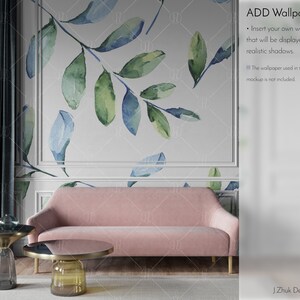 May include: A mockup of a living room with a pink sofa, two gold and glass coffee tables, and a teal blue curtain. The wall behind the sofa features a white background with a watercolor design of blue and green leaves. The text "ADD Wallpaper" is displayed in the upper right corner of the image. The text below the title reads "Insert your own wallpaper that will be displayed with realistic shadows. The wallpaper used in the mockup is not included."