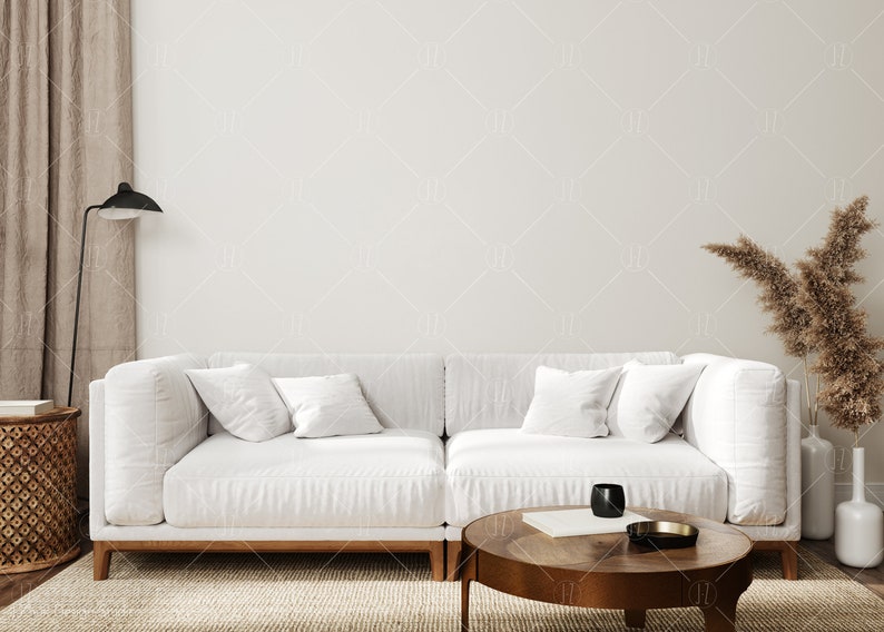 May include: A white sectional sofa with wooden legs sits in a living room with a brown rug, a wooden coffee table, a dried flower arrangement in a white vase, and a black floor lamp.
