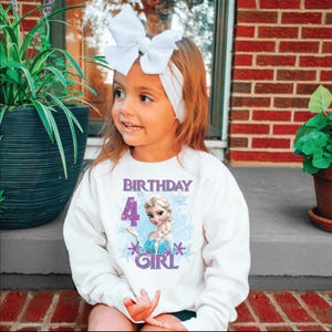 Puede incluir: Una sudadera blanca con el texto "BIRTHDAY 4 GIRL" y un dibujo animado. La sudadera la lleva un ni&ntilde;o peque&ntilde;o con un lazo y una diadema blancos.