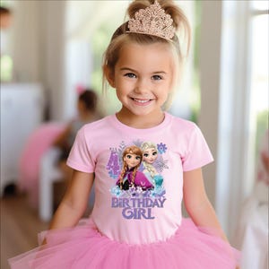 May include: A young girl wearing a pink t-shirt featuring Anna and Elsa from Frozen, the number 4, and the text "BIRTHDAY GIRL." She is also wearing a pink tutu and a gold tiara. The image is a portrait.