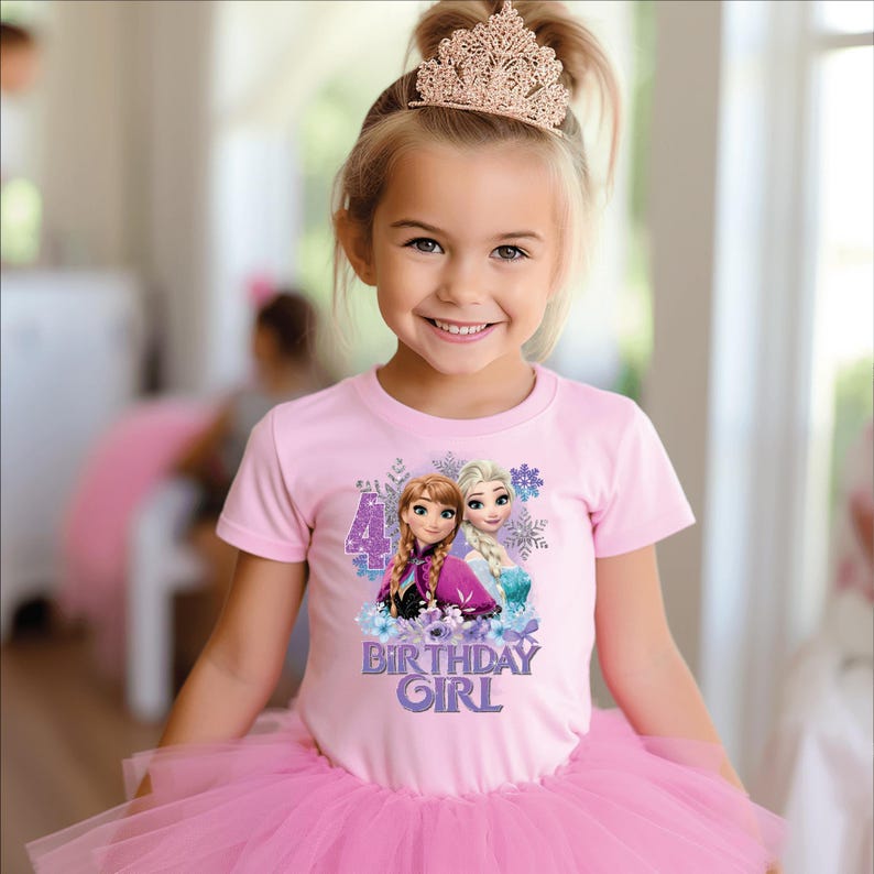 May include: A young girl wearing a pink t-shirt featuring Anna and Elsa from Frozen, the number 4, and the text "BIRTHDAY GIRL." She is also wearing a pink tutu and a gold tiara. The image is a portrait.