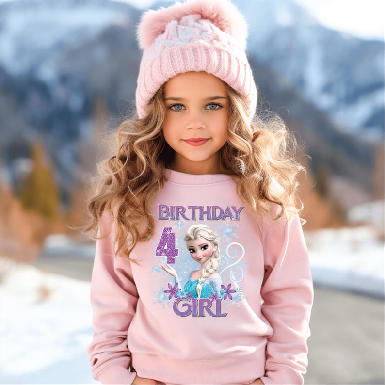 Puede incluir: Una ni&ntilde;a peque&ntilde;a con una sudadera rosa con el texto "BIRTHDAY 4 GIRL" y un gr&aacute;fico de princesa. Tambi&eacute;n lleva un gorro de punto rosa con un pomp&oacute;n. El fondo es una escena invernal borrosa.