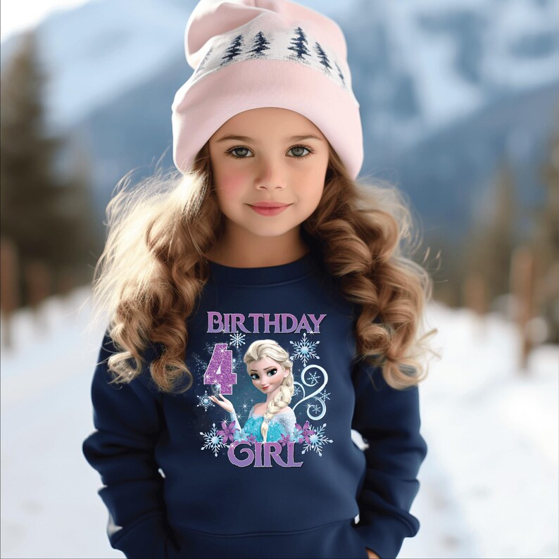 Puede incluir: Una ni&ntilde;a lleva una sudadera azul marino y un gorro rosa, con un fondo de escena invernal. La sudadera presenta el texto "BIRTHDAY 4 GIRL" con una imagen de princesa y copos de nieve.