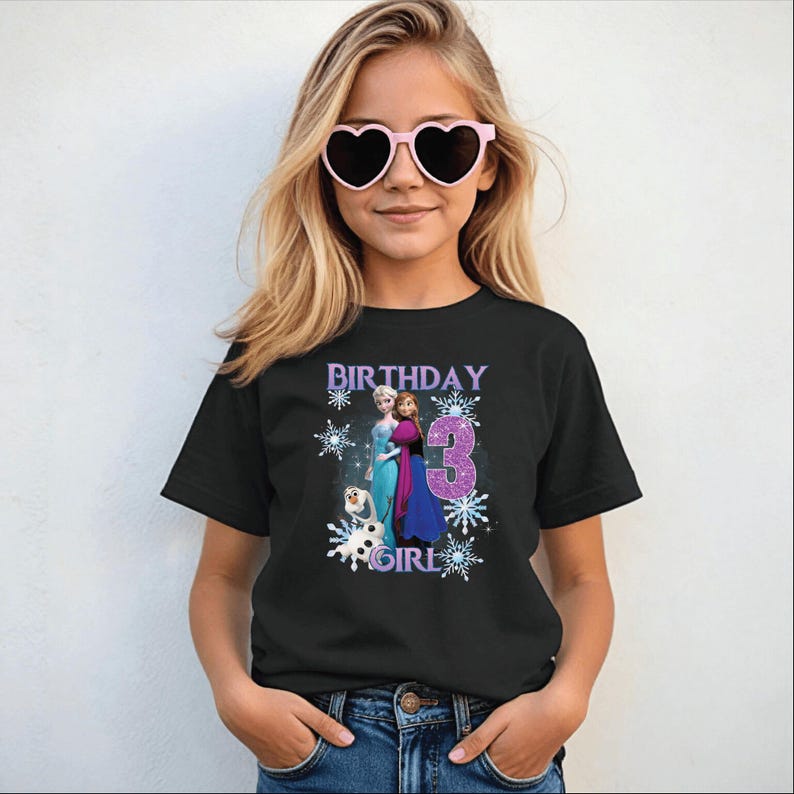 May include: Black t-shirt with a graphic featuring the text "BIRTHDAY GIRL 3" and images of characters from the movie Frozen. The design includes snowflakes and the characters Elsa, Anna, and Olaf.