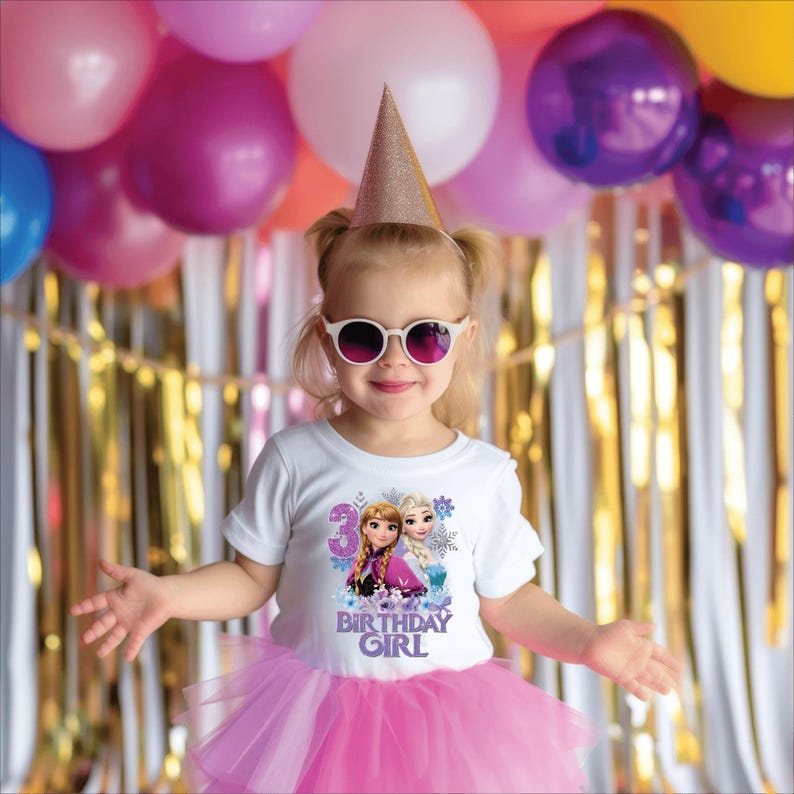 May include: A young girl wearing a white t-shirt with a graphic of two cartoon characters and the text "3 BIRTHDAY GIRL". She is wearing a pink tutu, sunglasses, and a gold party hat. Balloons and streamers are in the background.