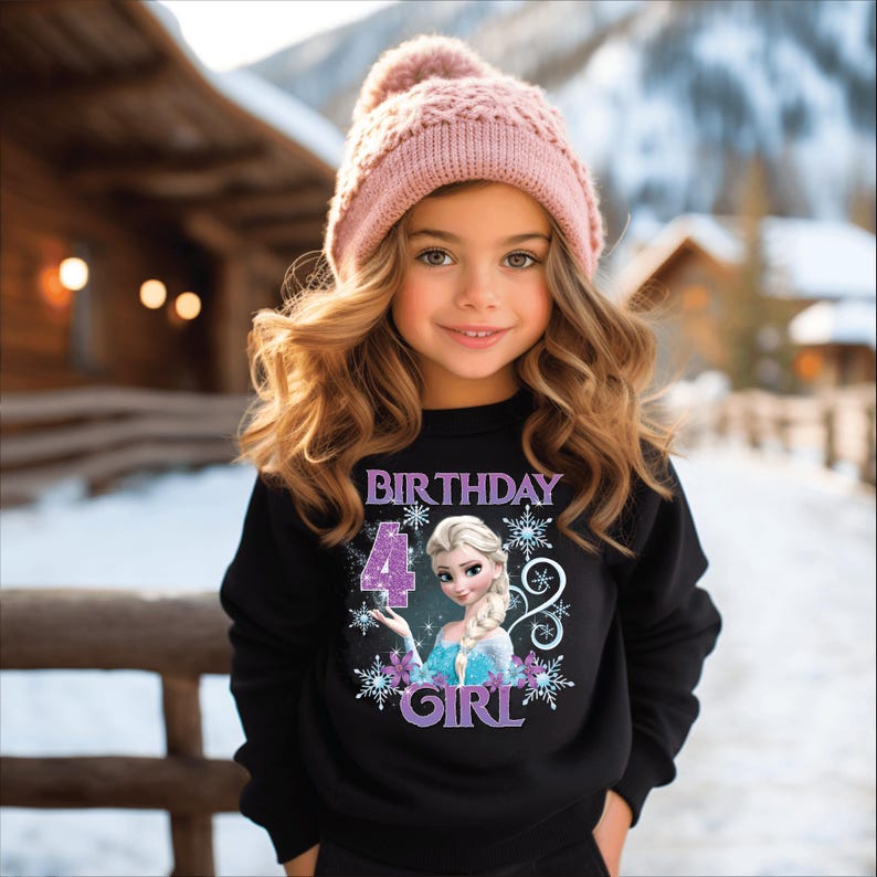 Puede incluir: Una ni&ntilde;a peque&ntilde;a con una sudadera negra con un personaje de dibujos animados y las palabras "BIRTHDAY 4 GIRL". Tambi&eacute;n lleva un gorro de punto rosa. El fondo es una escena invernal nevada.