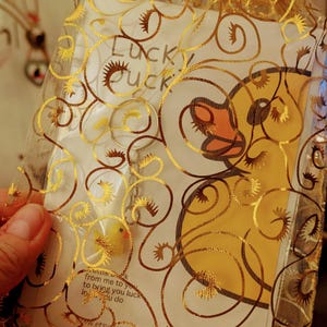 May include: A yellow rubber ducky charm in a gold mesh bag with a white card that says "Lucky Duck" and "from me to you to bring you luck in all you do".